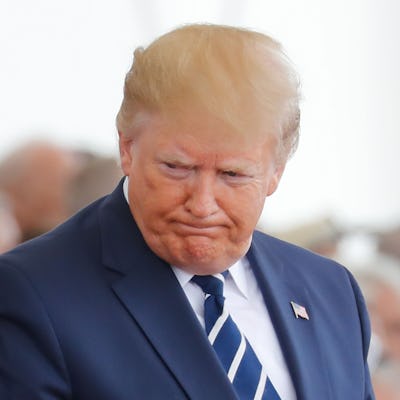 US President Donald Trump reacts as he takes his seat during an event to commemorate the 75th annive...