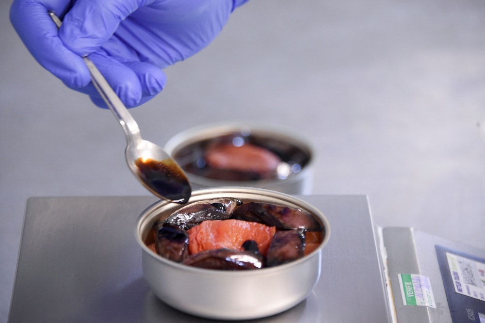 A chef from French chef Alain Ducasse's team adds balsamic vinegar reduction on a low-temperature co...