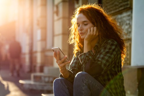 Worried young woman using a phone