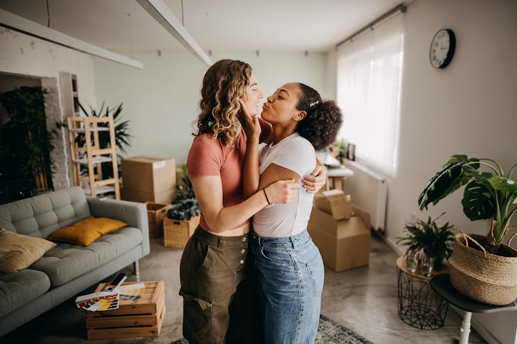 Two girlfriends are furnishing their new apartment together and sharing an intimate moment.