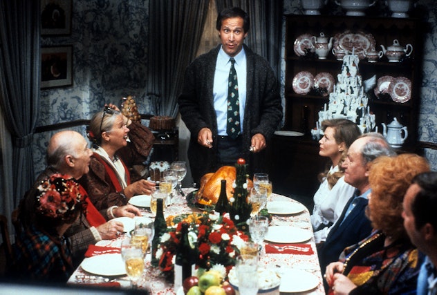 Chevy Chase stands at the head of the table in a scene from the film 'Christmas Vacation', 1989. (Ph...
