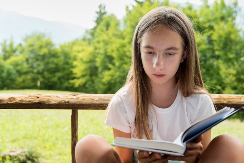 Young Girl in Summer Enjoy in the Mountain Peace Reading a Book
