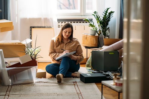 A woman writes a to-do list while moving. Find your daily horoscope for November 15, 2021.