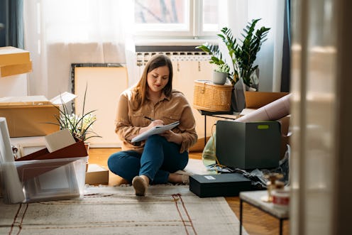 A woman writes a to-do list while moving. Find your daily horoscope for November 15, 2021.