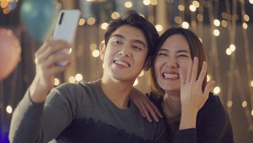 Affectionate happy couple announcing their engagement while on a video call