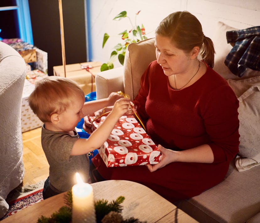 Family Christmas in old Danish house. Gift exchange Christmas evening after dance around the Christm...