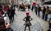NEW YORK, NY - MARCH 8: 'The Fearless Girl' statues stands across from the iconic Wall Street chargi...