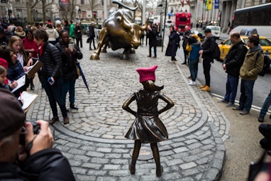 NEW YORK, NY - MARCH 8: 'The Fearless Girl' statues stands across from the iconic Wall Street chargi...