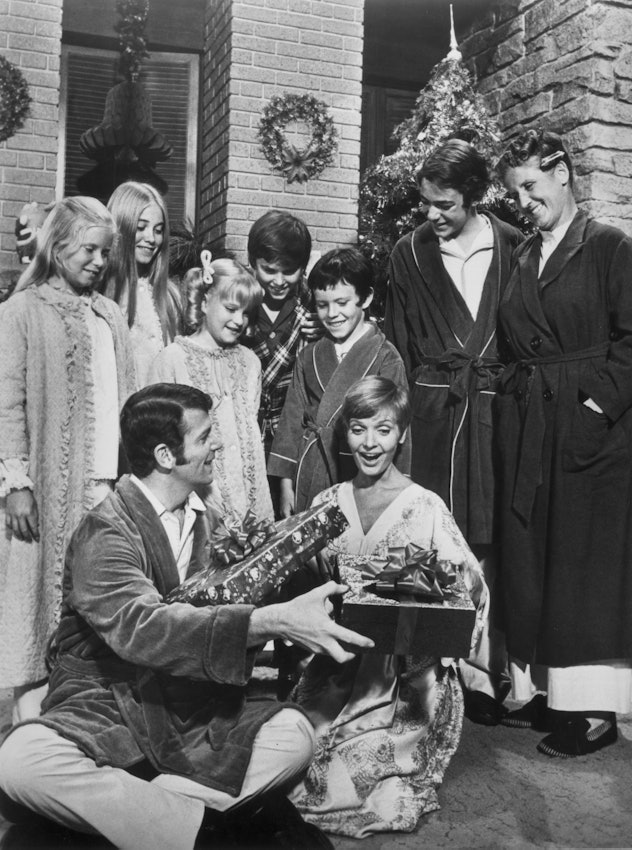 circa 1975:  The cast of the television series 'The Brady Bunch' stands and watches American actors ...
