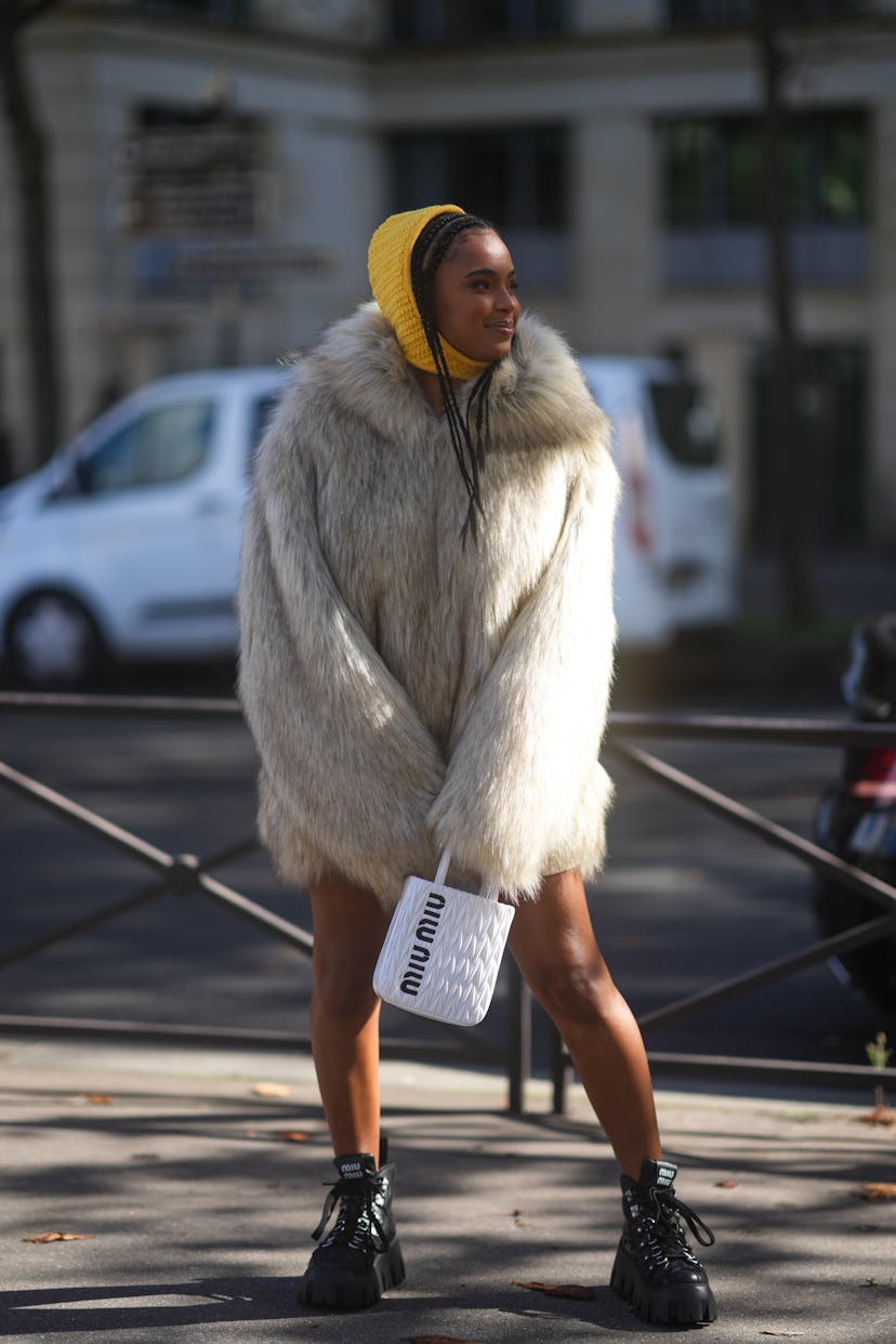 PARIS, FRANCE - OCTOBER 05: Paola Locatelli wears a yellow braided wool hood / balaclava, a white an...