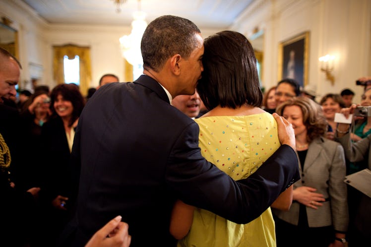 U.S. President Barack Obama whispers into First Lady Michelle Obama's ear during the White House Cin...