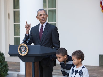 US President Barack Obama stands with his nephews Austin and Aaron Robinson before he pardons the Na...