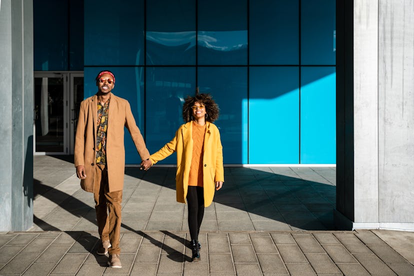 A young couple walking while holding hands