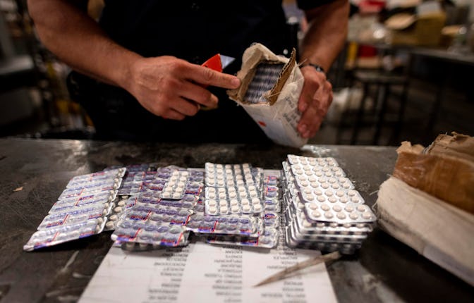 An officer from the US Customs and Border Protection, Trade and Cargo Division finds Oxycodon pills ...