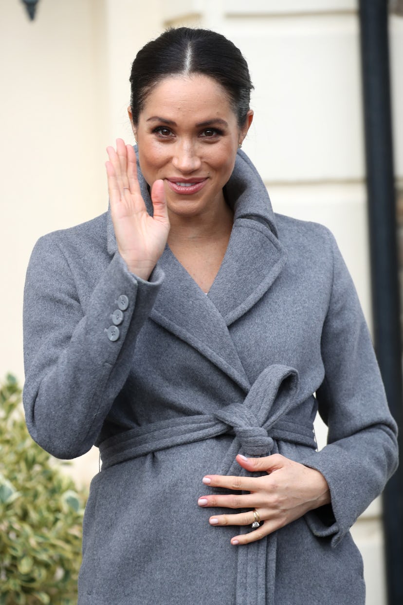 Meghan Markle wraps up in a coat.