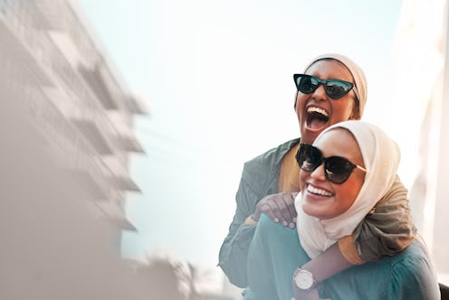 A woman in hijab gives another friend a piggy-back ride. Here's your daily horoscope for November 22...