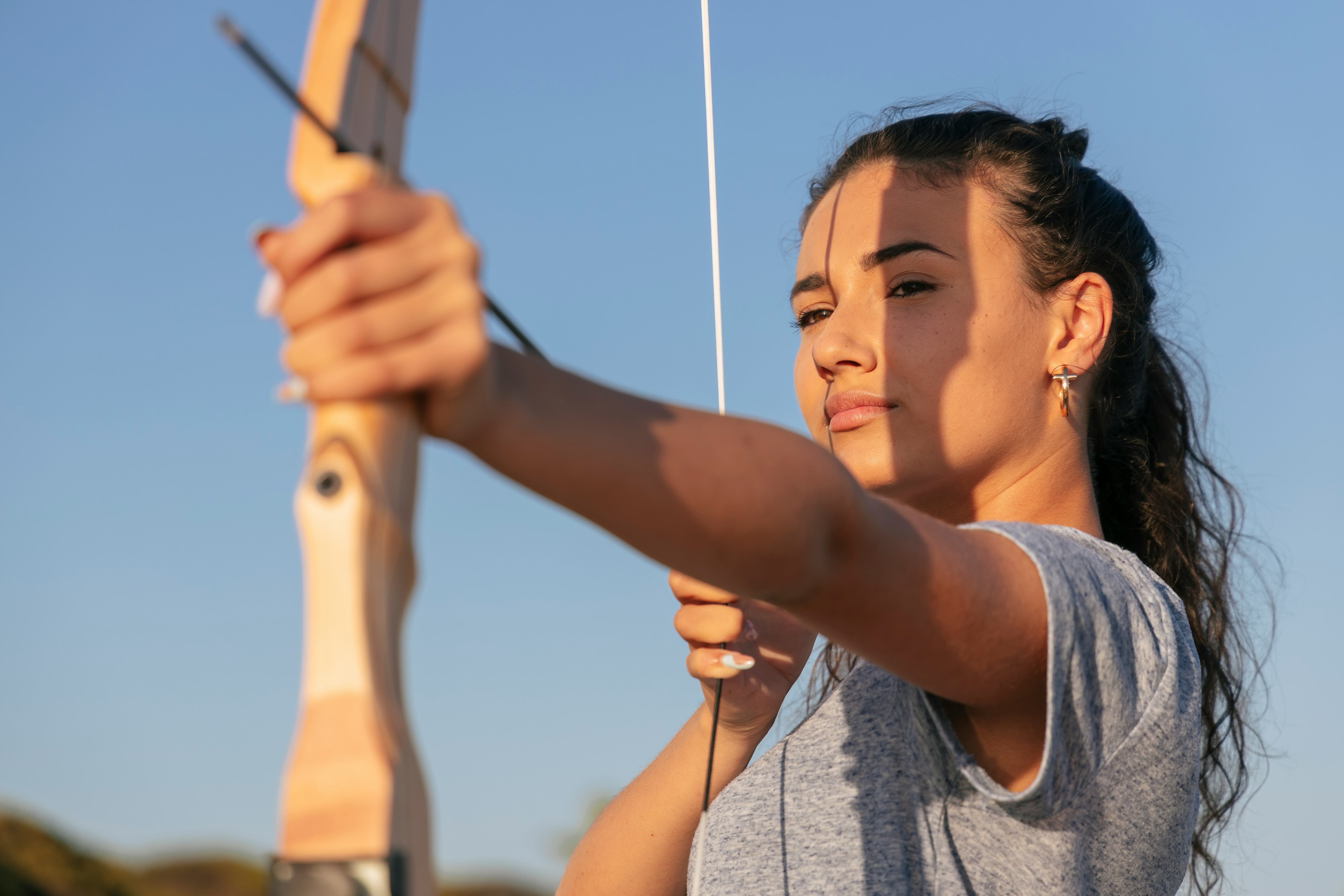 A woman threads a bow and arrow. Here's how to make the most of Sagittarius season 2021.