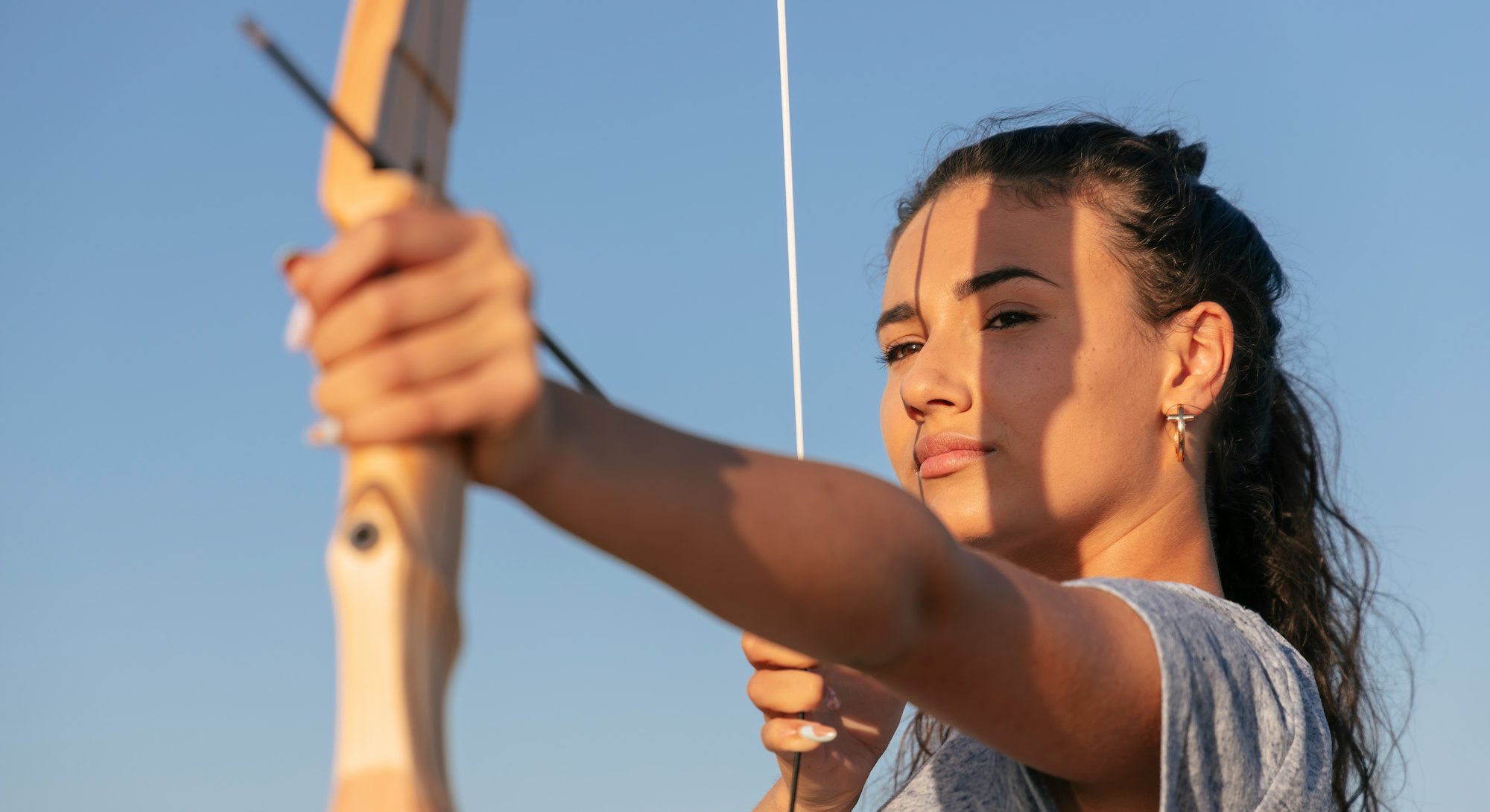 A woman threads a bow and arrow. Here's how to make the most of Sagittarius season 2021.