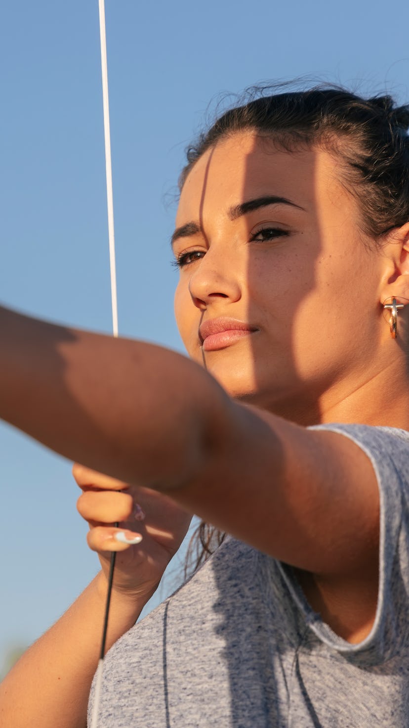 A woman threads a bow and arrow. Here's how to make the most of Sagittarius season 2021.