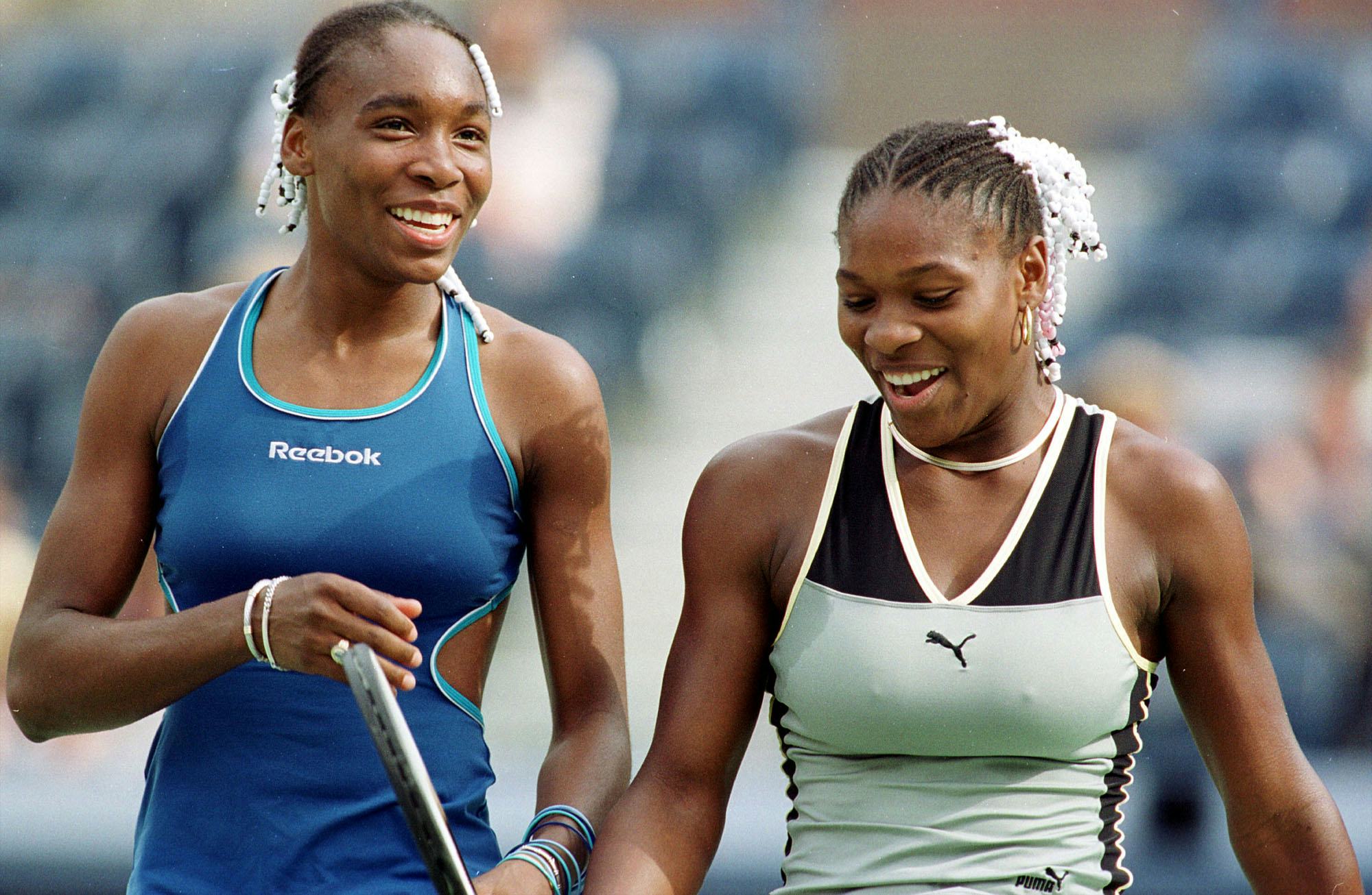 Venus Williams(L) and her sister Serena Williams share a light moment during a Women's Doubles match...