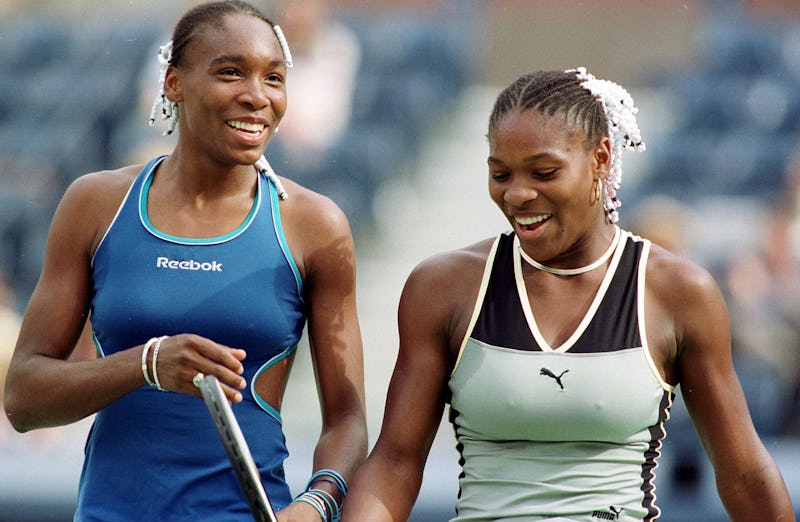 Venus Williams(L) and her sister Serena Williams share a light moment during a Women's Doubles match...