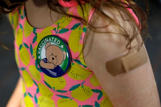 A child wears a pin she received after receiving her first dose of the Pfizer Covid-19 vaccine at th...
