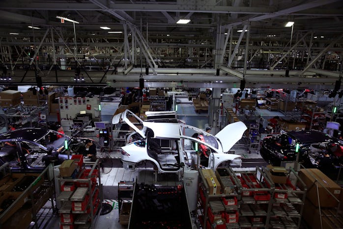 A Tesla Model X is worked on a factory line with Tesla X's and Tesla S's  at the Tesla factory on We...