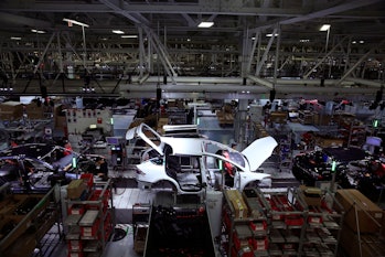 A Tesla Model X is worked on a factory line with Tesla X's and Tesla S's  at the Tesla factory on We...