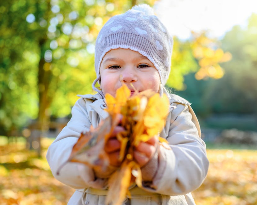 Happy kid enjoying fall day. Outdoor activites for kids