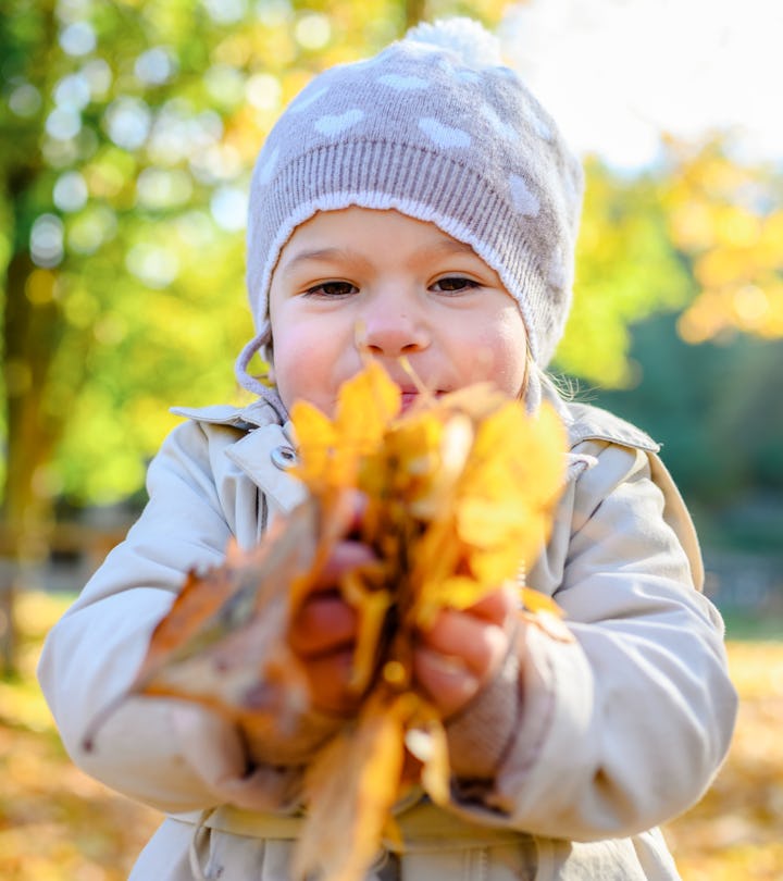 Happy kid enjoying fall day. Outdoor activites for kids