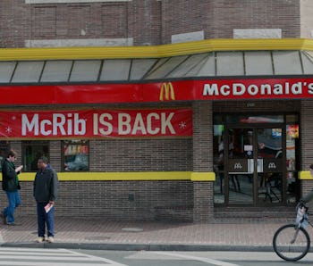 Pedestrians move past a McDonald's restaurant on November 2, 2010 in Washington, featuring a sign an...