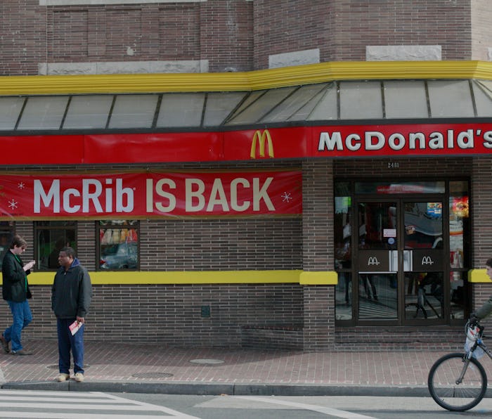 Pedestrians move past a McDonald's restaurant on November 2, 2010 in Washington, featuring a sign an...