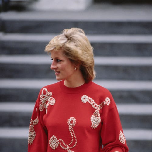 Princess Diana wearing a red sweater with gold designs. 