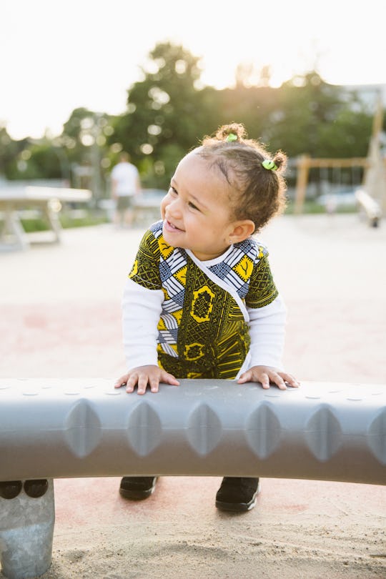 Carefree toddler playing on a playground in summer