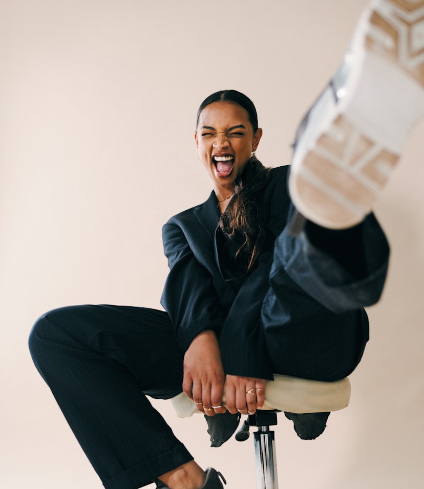 young woman excitedly kicks foot towards camera as she reflects on the best day of 2022 for her zodi...