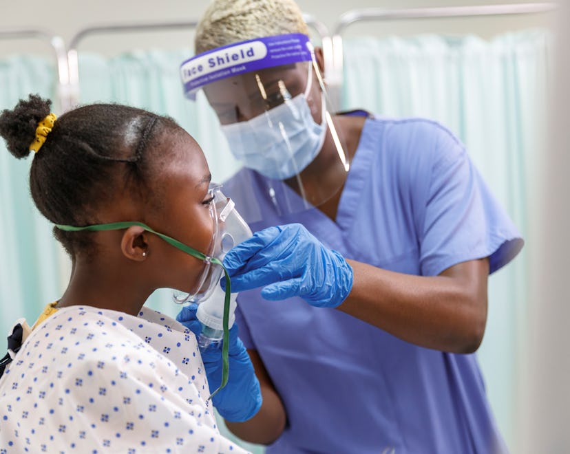 An elementary age black girl who is hospitalized while sick with Coronavirus sits in her hospital be...
