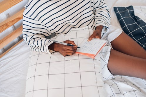 A woman sitting among checked sheets crosses items off a to-do list. Highly productive people share ...