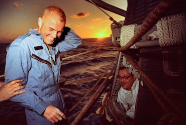 (Original Caption) At sea aboard destroyer NOA as the sun sets, Lt. Col. John Glenn stands by as tec...