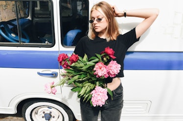 Beautiful blonde girl with a bouquet of peonies. Lifestyle of a modern and stylish woman.