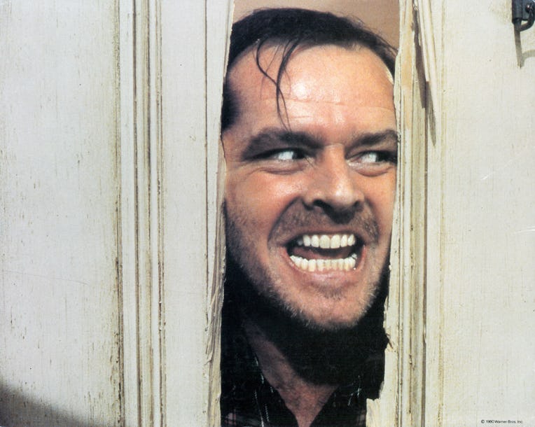 Jack Nicholson peering through axed in door in lobby card for the film 'The Shining', 1980. (Photo b...