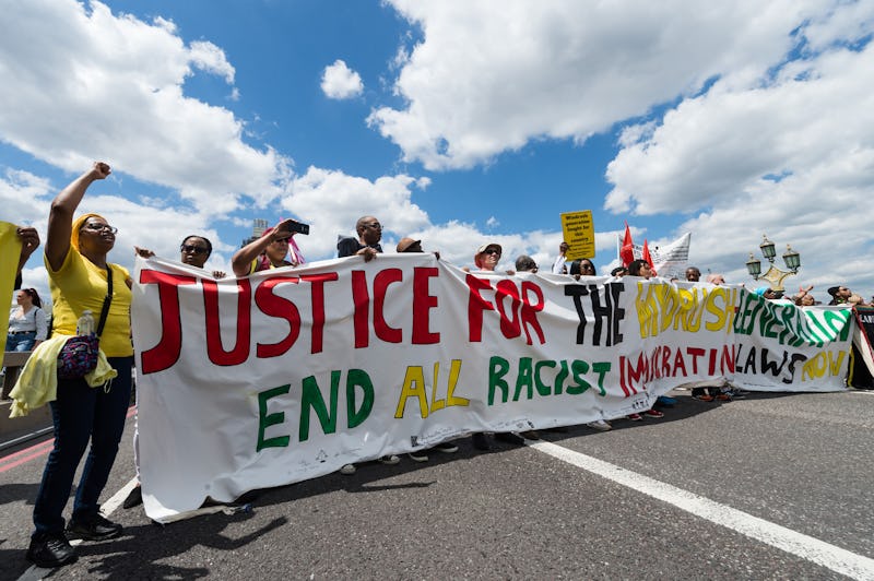 A group of protesters gather on Westminster Bridge to mark the first official Windrush Day with a de...