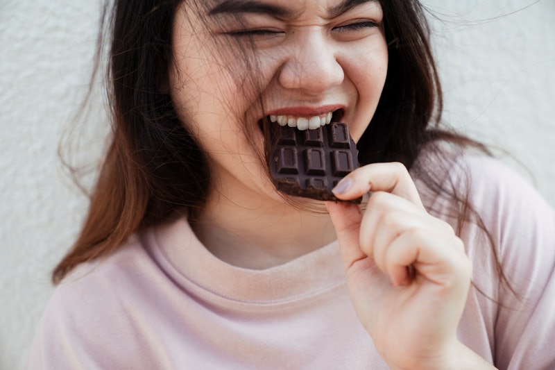 woman biting into a piece of chocolate