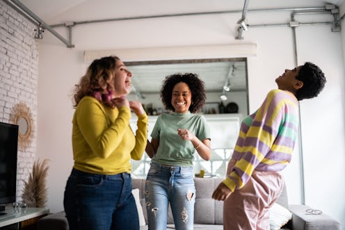 Female friends dancing and having fun at home