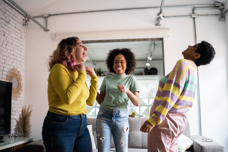 Female friends dancing and having fun at home