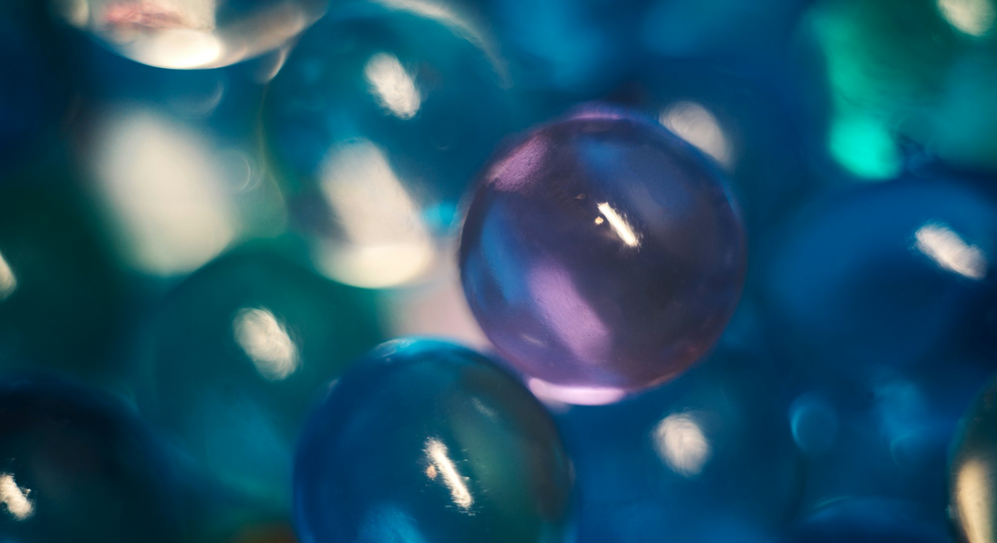 Hydrogel beads close-up, abstract background. Blue purple orbeez.