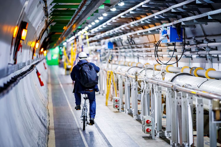 A man rides his bicycle along the beam line of the Large Hadron Collider (LHC) in a tunnel of the Eu...