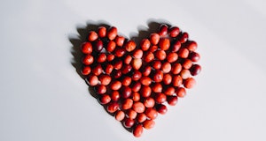 Group of cranberries in a heart shaped disposition on a white background. Copy Space.