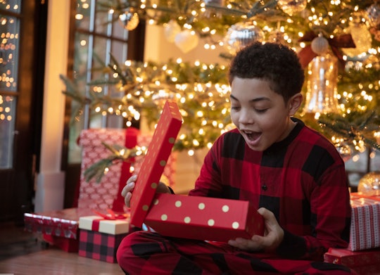 Mixed race teenager boy opening Christmas presents
