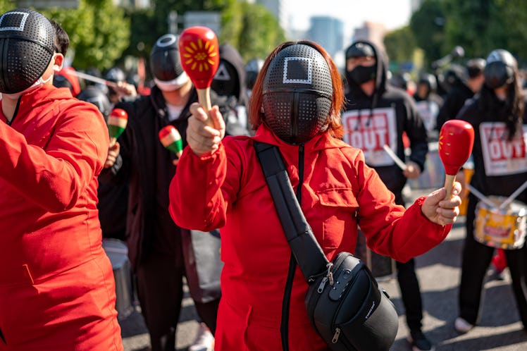 Members of the Korean Confederation of Trade Unions wear masks costumed in the Netflix series Squid ...