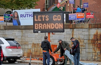 BOSTON, MA - November 2:  People look over the electric sign with a "u201clets go Brandon"u201d slog...